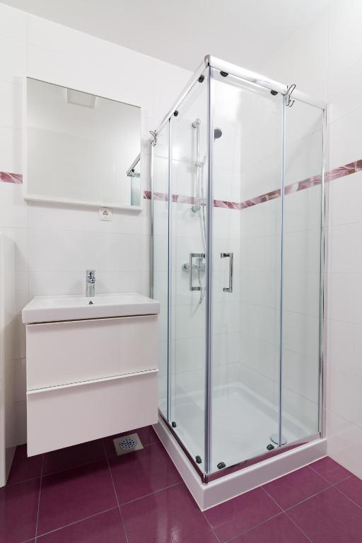 un bagno con doccia in vetro e lavandino di Sobe Meta a Brezje
