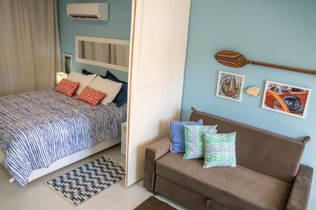 琵琶的住宿－Apartamento Solar Água 107，一间卧室配有一张床、一把椅子和镜子