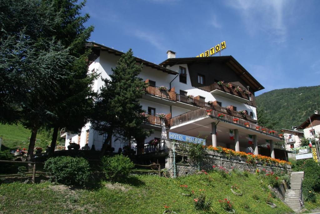 Ein Gebäude mit Leuten, die auf den Balkonen sitzen in der Unterkunft Hotel Bellevue in Gignod