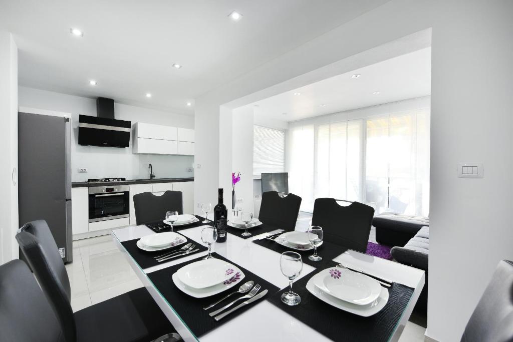 eine Küche und ein Esszimmer mit Tisch und Stühlen in der Unterkunft Apartman Kresan in Sukošan