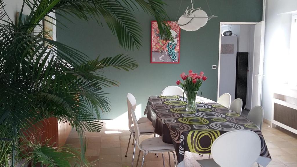 a dining room with a table and white chairs at Maison Vintage Ardenne in Awenne