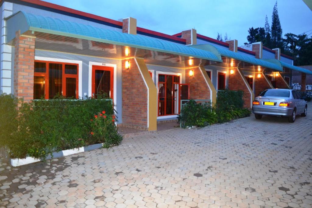 a house with a car parked in front of it at Wailers Lodge in Kigali