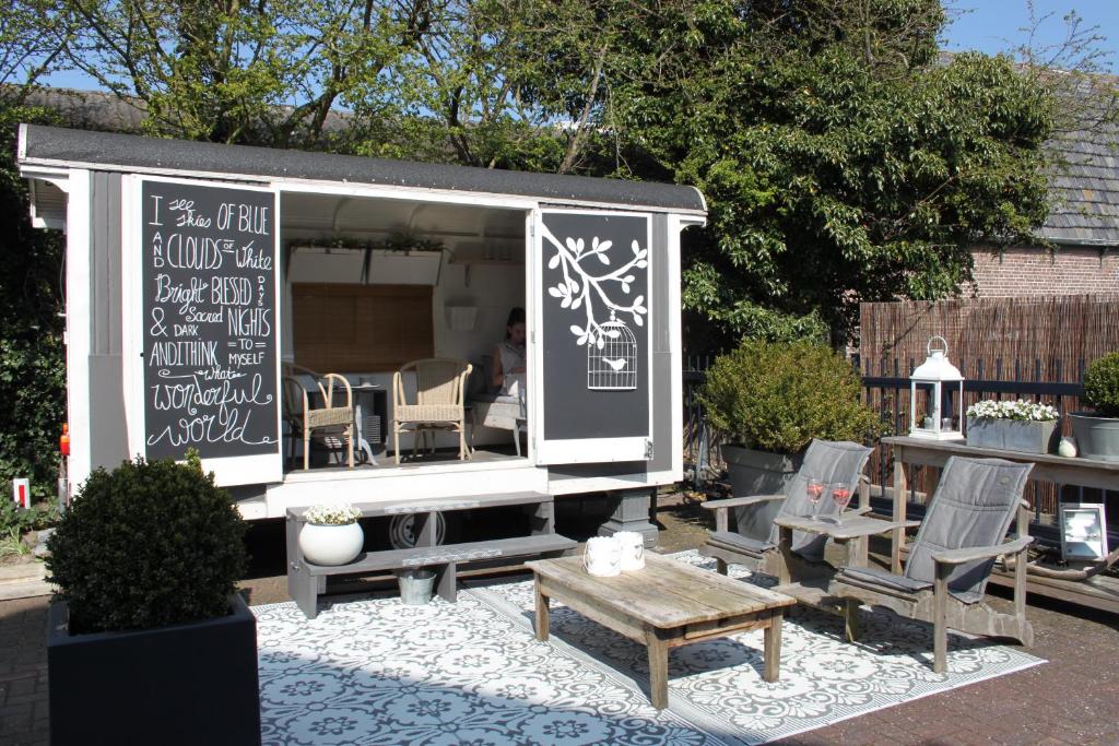 een schuur met een tafel en stoelen en een bank bij Raadhuis Egmond in Egmond aan den Hoef