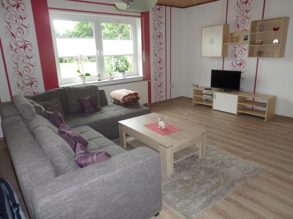 een woonkamer met een bank en een tafel bij Ferienwohnung Baumann in Westoverledingen