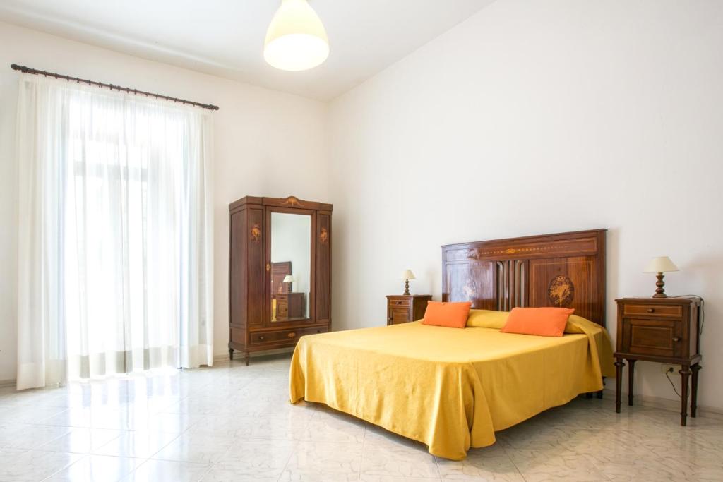 ソレントにあるOrsola Maisonのベッドルーム1室(オレンジ色の枕と鏡付きのベッド1台付)