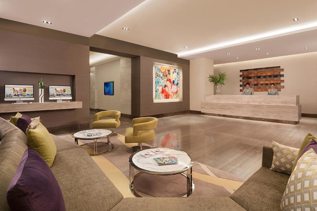 a living room with a couch and chairs at Citadines Salcedo Makati in Manila