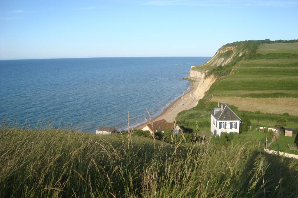 a house on the side of a hill next to the ocean at Le Clos Saint Jean in Sainte-Honorine-des-Pertes