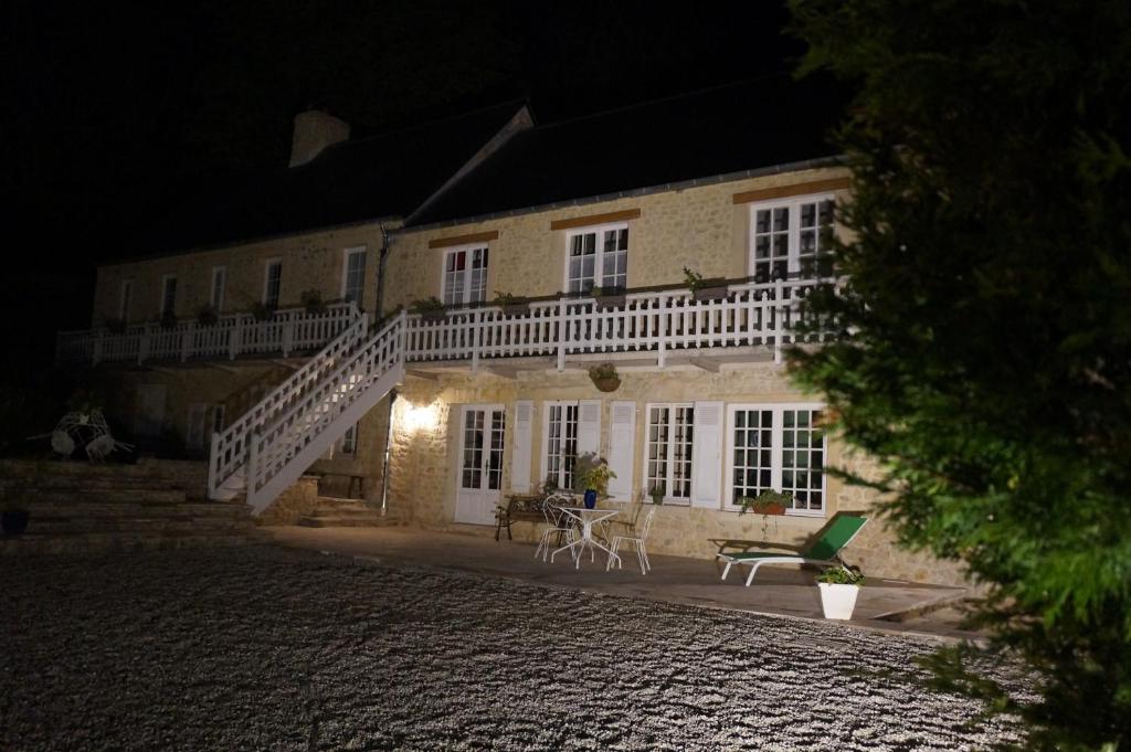 a building with a staircase in front of it at night at Le Clos Saint Jean in Sainte-Honorine-des-Pertes