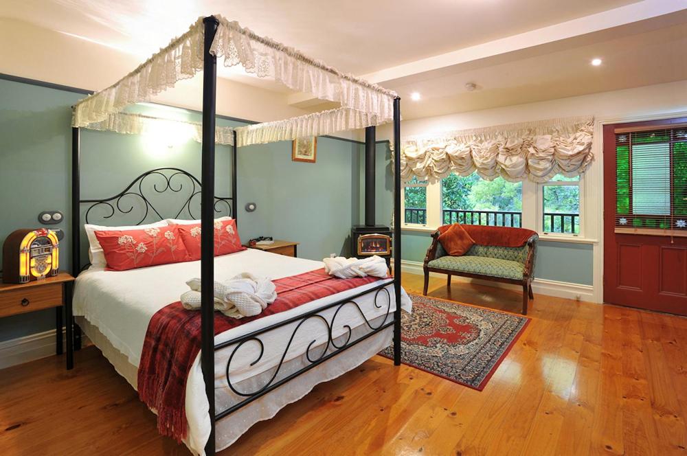 a bedroom with a canopy bed and a chair at Belgrave Bed and Breakfast in Belgrave