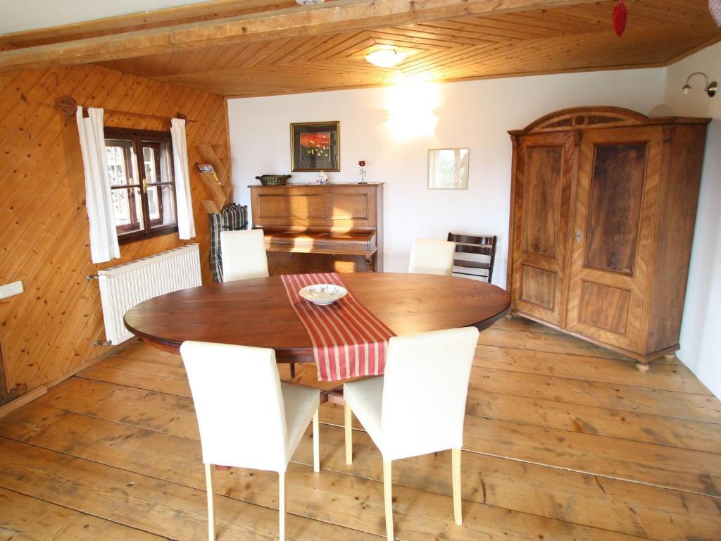 a dining room with a wooden table and white chairs at Holiday home in Liebenfels in Carinthia with sauna in Liebenfels