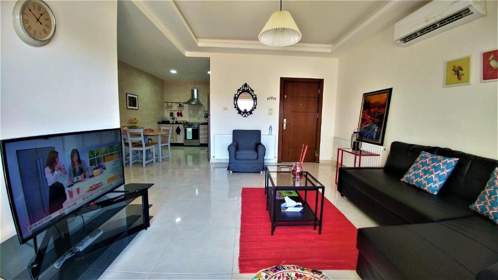 a living room with a couch and a flat screen tv at Double Key by HR in Amman