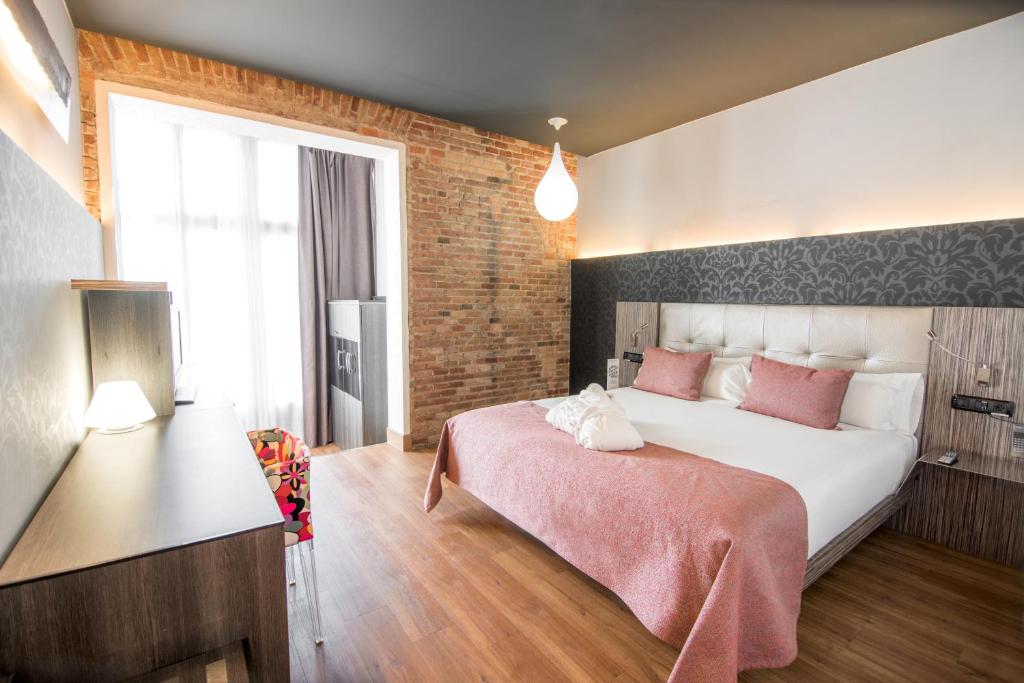 a bedroom with a large bed with pink pillows at Petit Palace Museum in Barcelona