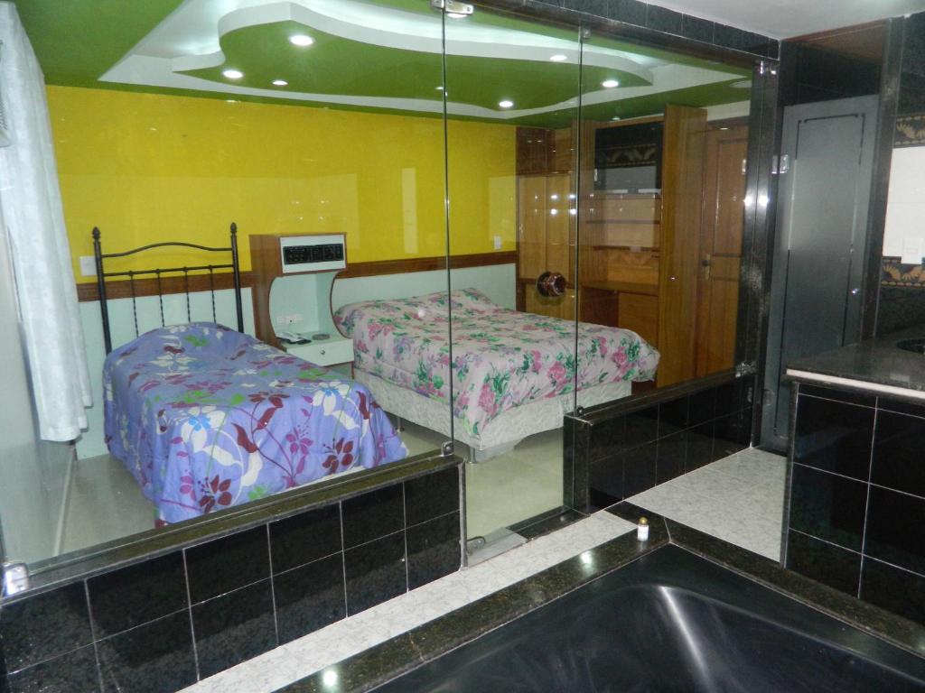 a room with two beds and a mirror at Midway Motel (Adult Only) in Rio de Janeiro