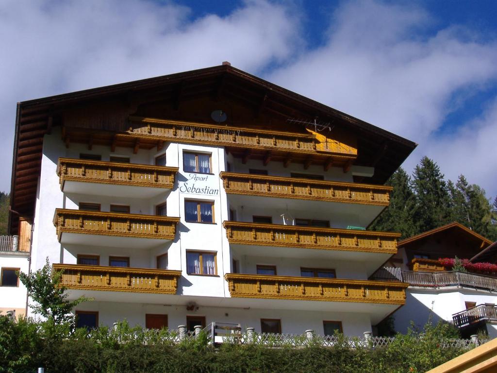 a white building with wooden balconies on it at Apart Sebastian in Kappl