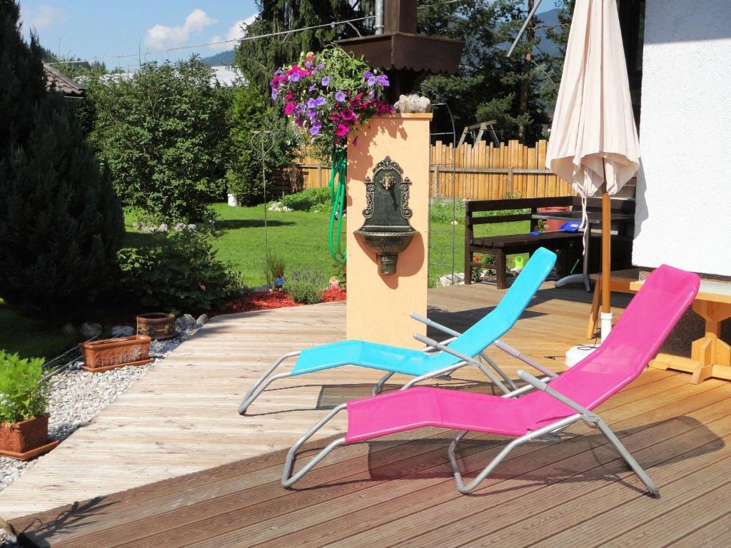 two chairs and an umbrella on a deck at Plush Apartment in Altenmarkt im Pongau near Ski Area in Altenmarkt im Pongau