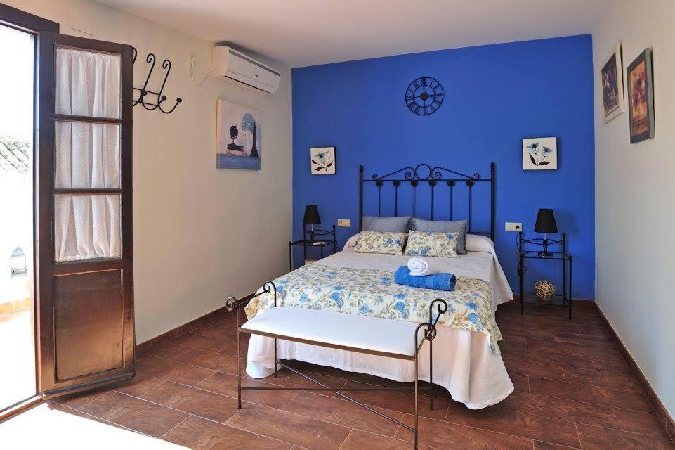 1 dormitorio con 1 cama con pared azul en De Patios, en Córdoba