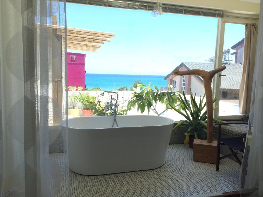 a bath tub in a room with a view of the ocean at Kenting Sun Light Inn in Eluan