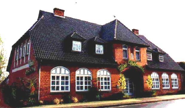 Hotel-Restaurant Pfeffermühle في Dörverden: منزل من الطوب الأحمر كبير مع سقف أسود