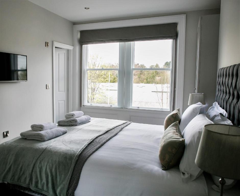 a bedroom with a large bed with a large window at Spa Apartments in Harrogate