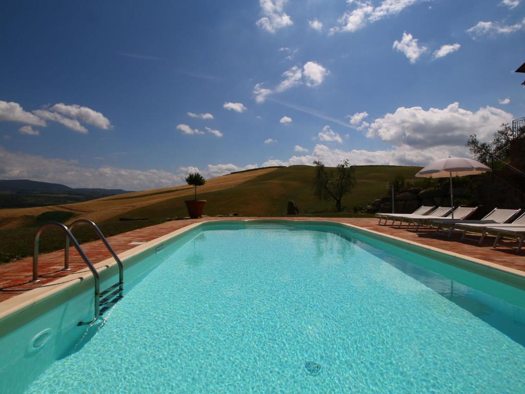 una piscina con vista sulle colline e sul cielo di Belvilla by OYO Montenero a Montenero