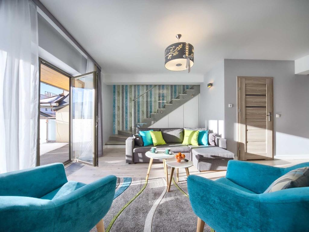 ザコパネにあるVisitZakopane - Mountain Pass Apartmentのリビングルーム(青い椅子、ソファ付)