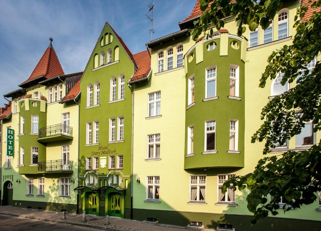 a row of green and yellow buildings at Hotel Stary Malbork in Malbork