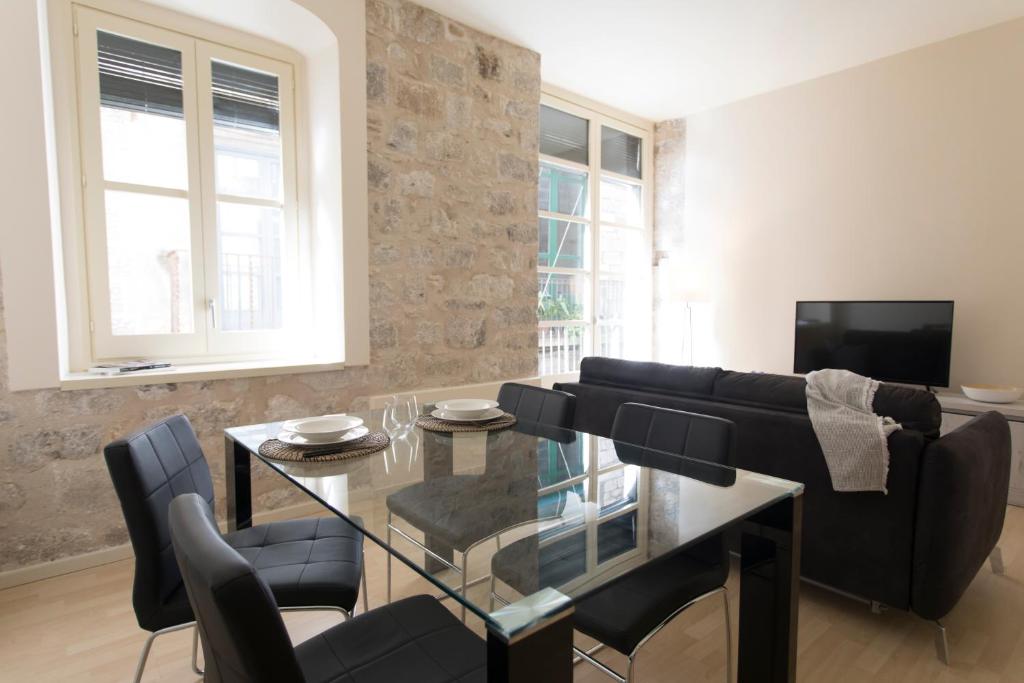 un salon avec une table en verre et un canapé dans l'établissement Bravissimo Cort Reial-1A, à Gérone
