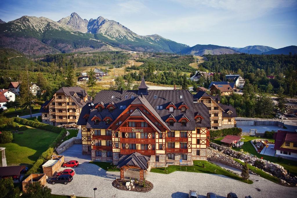 an aerial view of a large building with mountains in the background at APLEND Hotel Kukučka in Vysoke Tatry - Tatranska Lomnica.