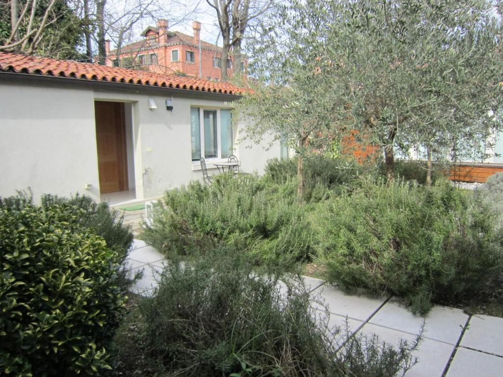 ogród przed domem z drzewami i krzakami w obiekcie Belvilla by OYO Tipologia trio w Wenecji