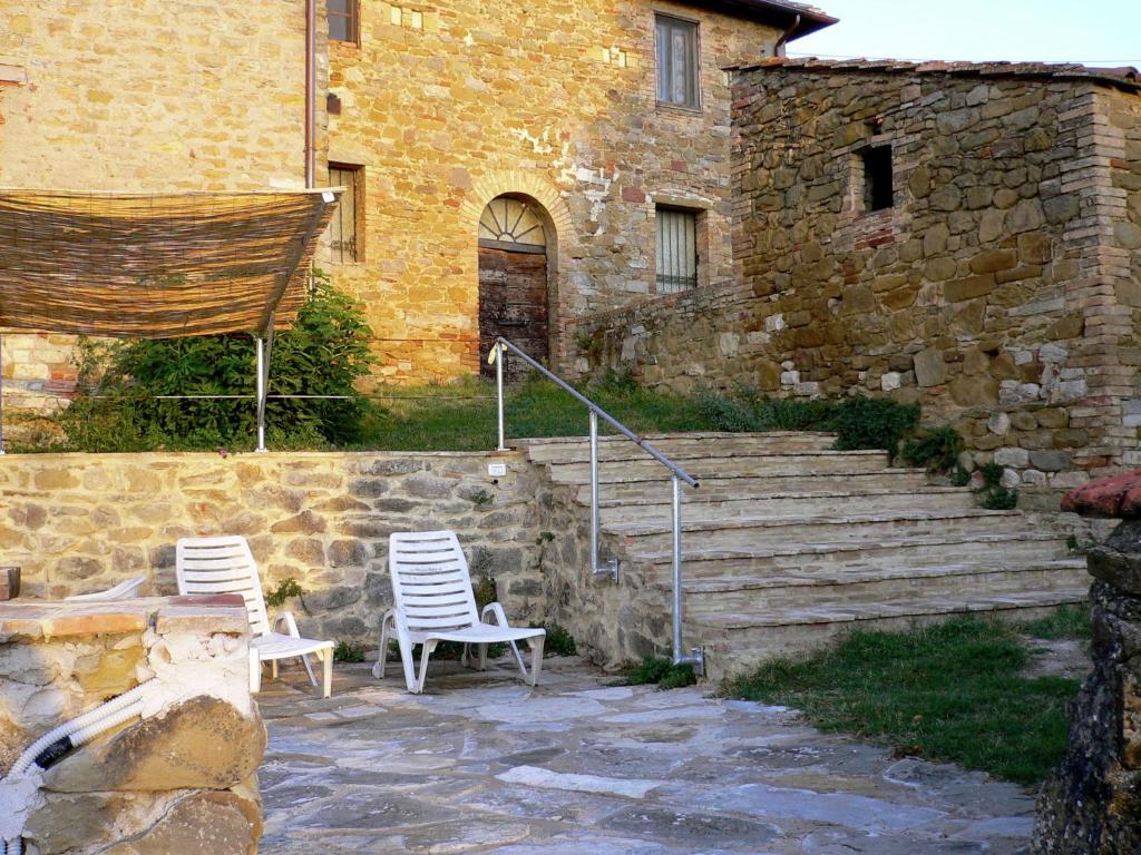 2 chaises et une table en face d'un bâtiment dans l'établissement Belvilla by OYO Nespolo Due, à San Savino