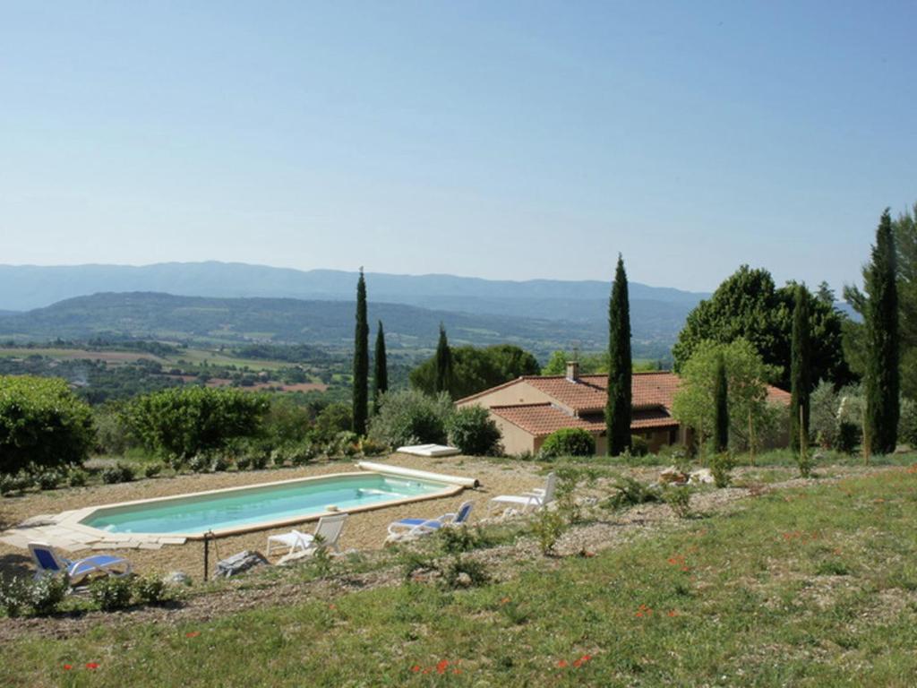 a pool on a hill with chairs and a house at Lovely Holiday Home in Saint Saturnin l s Apt with Pool in Saint-Saturnin-lès-Apt