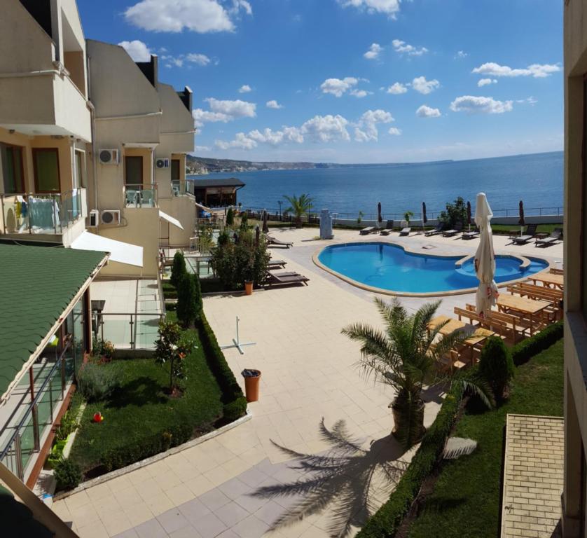 a view of a resort with a swimming pool and the ocean at Aparthotel Golf Coast in Kavarna