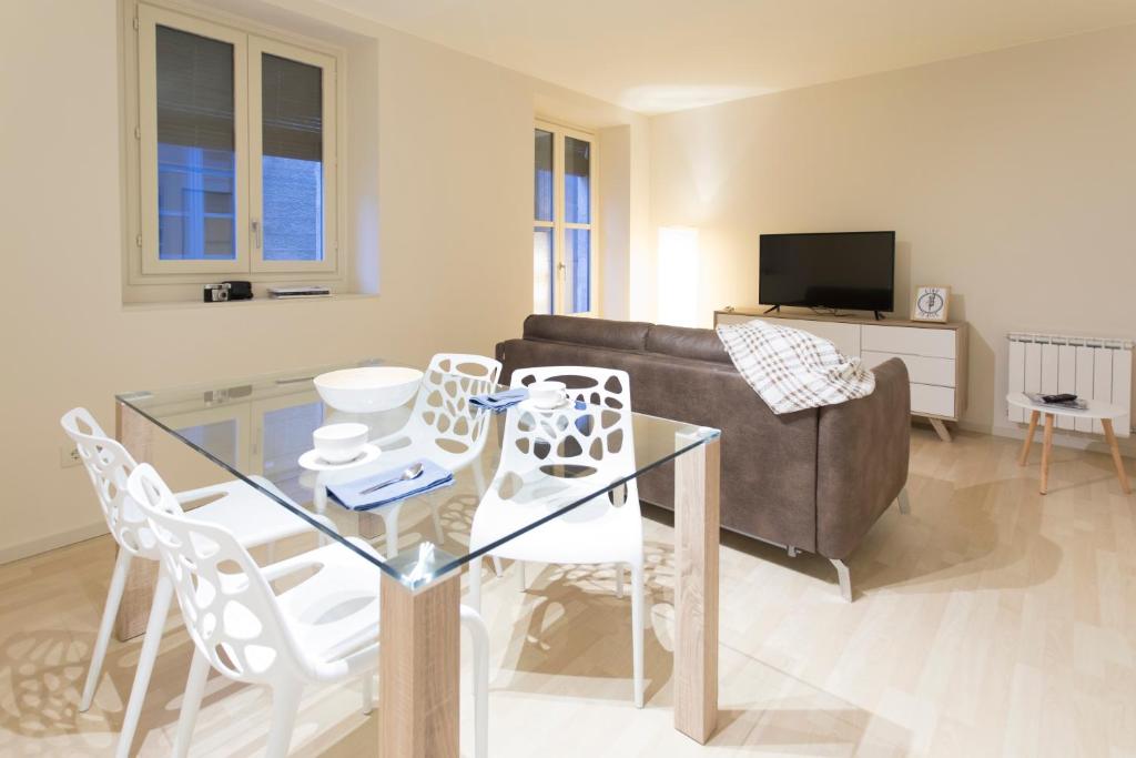 a living room with a glass table and white chairs at Bravissimo Cort Reial-3A in Girona