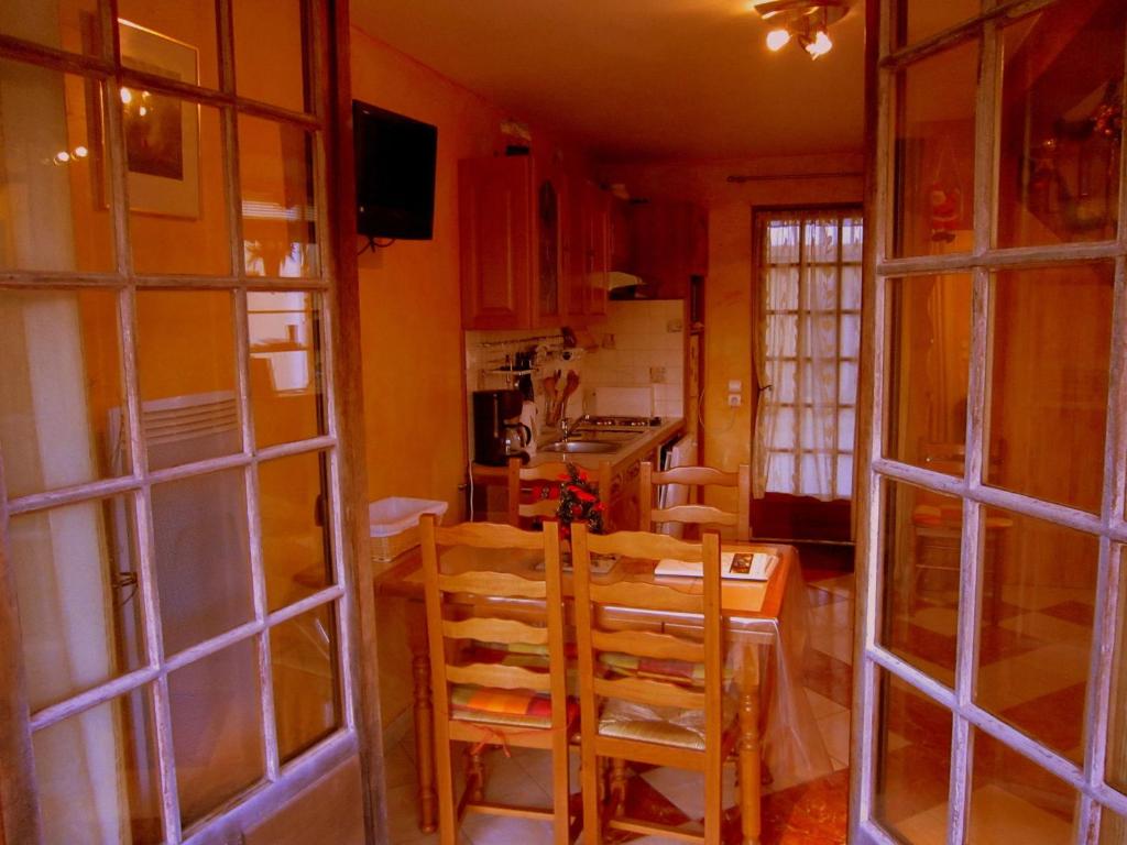 a kitchen with a table and chairs in a room at Cozy Cottage in Vaires sur Marne with Garden in Chelles