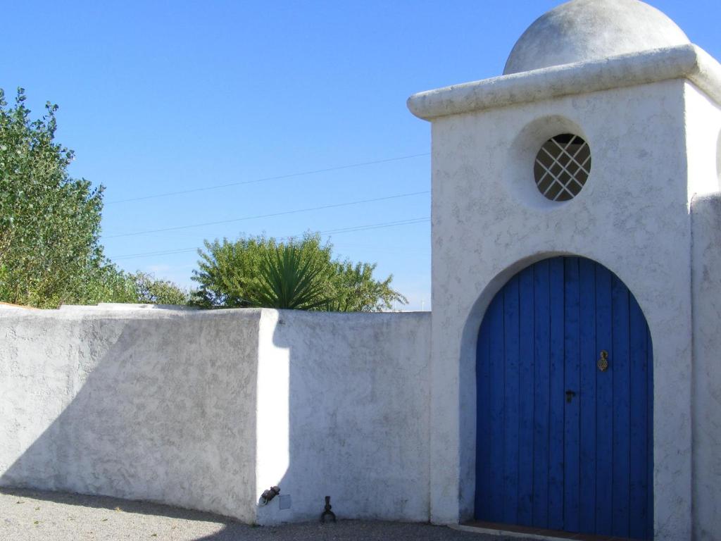 a church with a blue door and a wall at Holiday home with private pool in Villedaigne