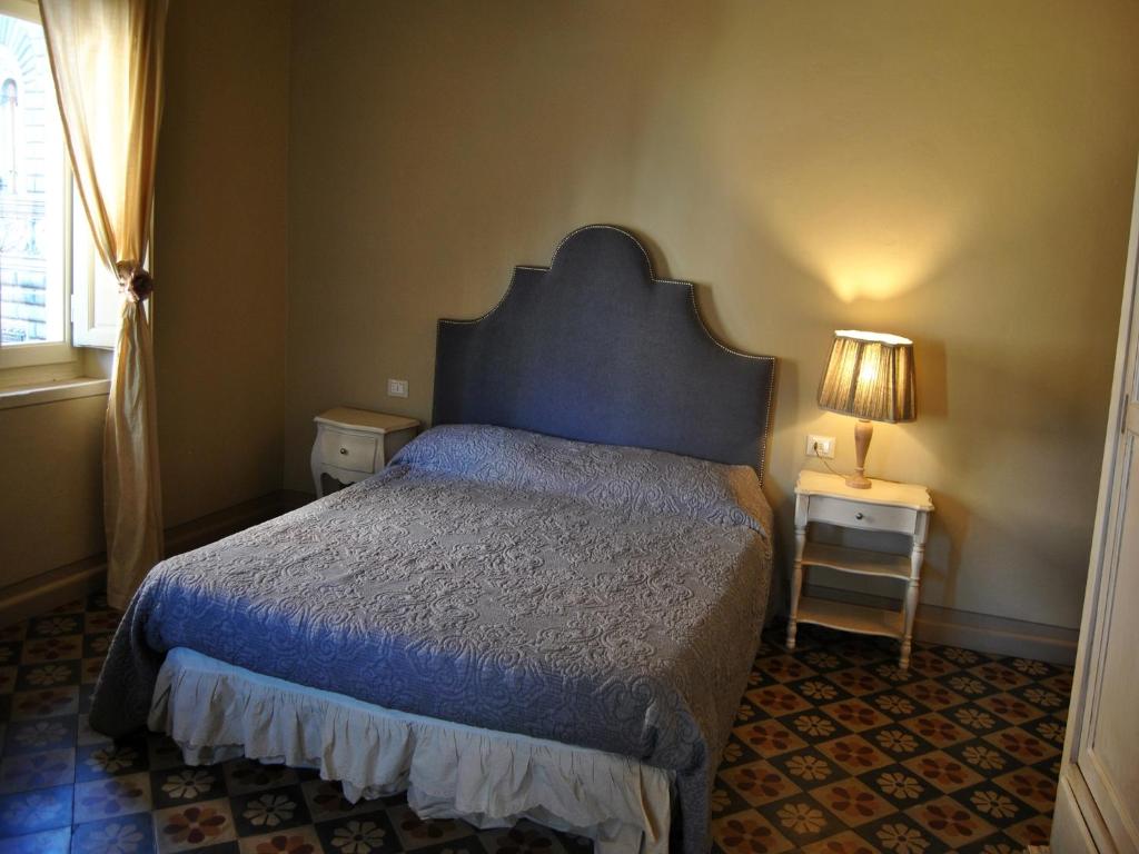 sypialnia z łóżkiem, lampką i oknem w obiekcie Appartamento il Battistero w mieście Pistoia