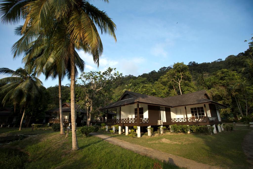 a house with a palm tree in front of it at Perhentian Island Resort in Perhentian Islands