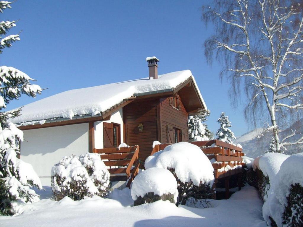 ル・メニルにあるComfy chalet with dishwasher, in the High Vosgesの屋根に雪が積もった丸太キャビン