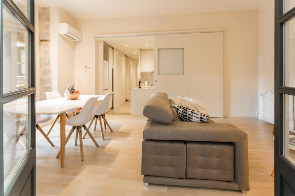 a living room with a dining room table and a couch at Bravissimo Cort Reial-3B in Girona