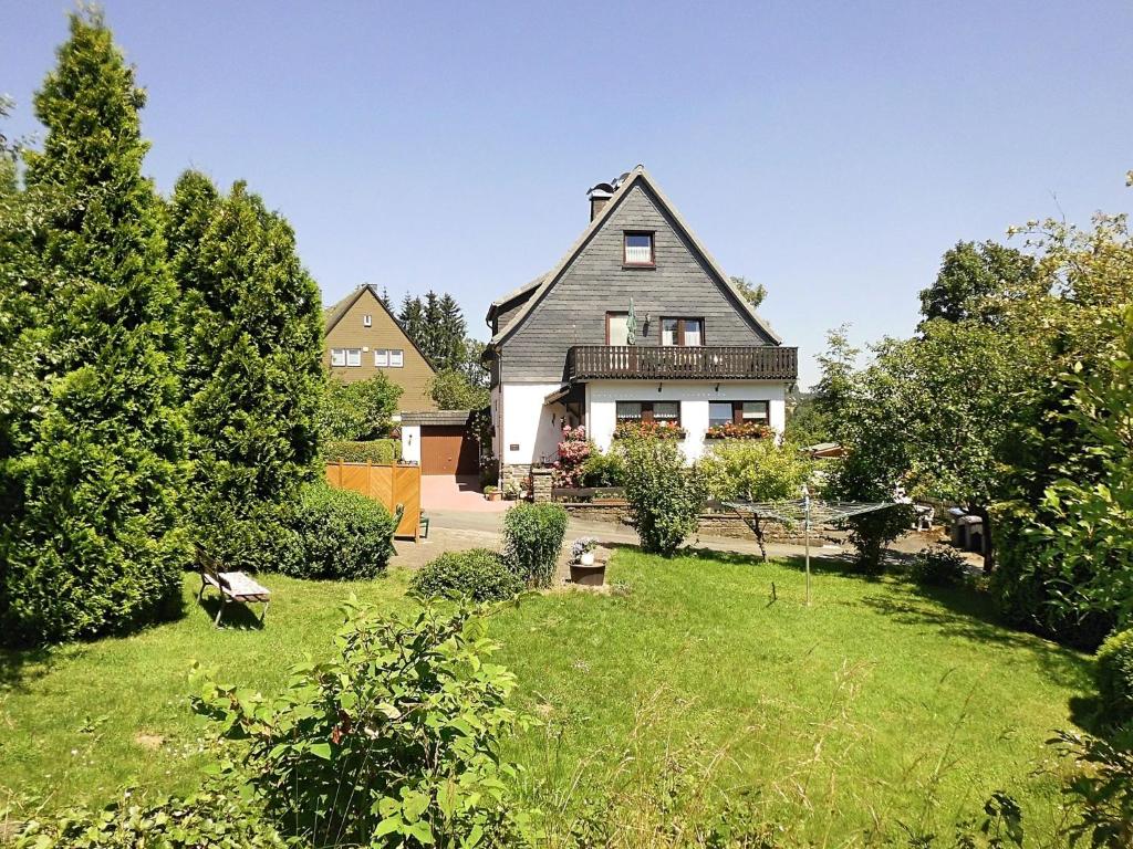 ein Haus mit einem grünen Hof mit einem Haus in der Unterkunft Apartment in Langewiese Sauerland with garden in Winterberg