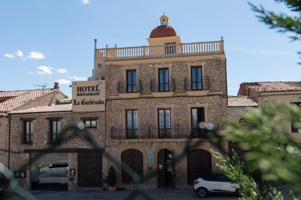 a brick building with a balcony on top of it at La Garbinada Hotel in Grañena de las Garrigas