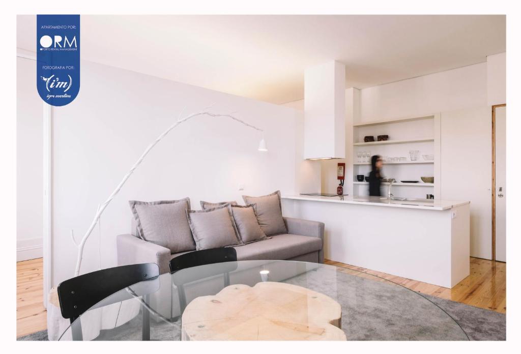 uma sala de estar com uma mesa de vidro e um sofá em ORM - Cativo Apartments no Porto