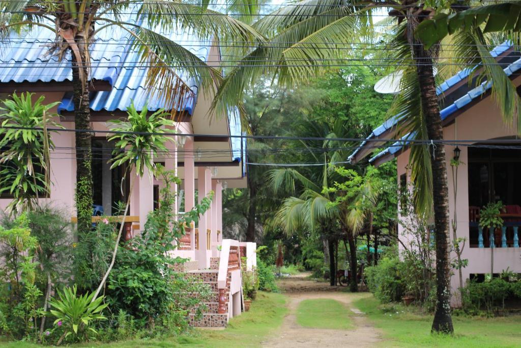 a house with palm trees in front of it at Chaiwat Resort in Laem Sing