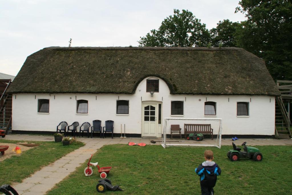 duży biały dom z dachem krytym strzechą w obiekcie Kristiansminde Farm Holiday w mieście Tistrup