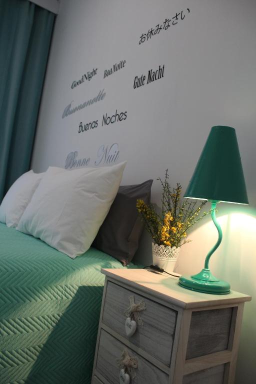 a bedroom with a bed with a green lamp on a night stand at Casa do Rio - Penacova in Raiva