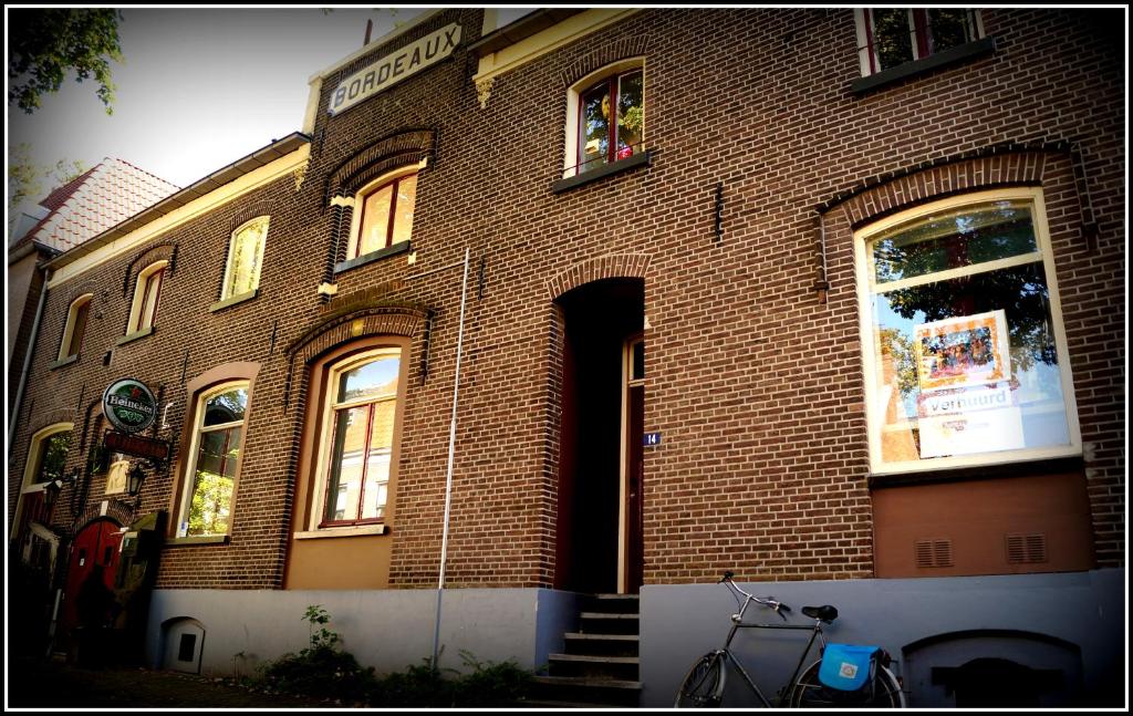 un edificio de ladrillo con una bicicleta estacionada frente a él en Hostel Barbarossa, en Nijmegen