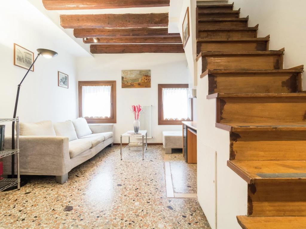 ein Wohnzimmer mit einem Sofa und einer Treppe in der Unterkunft Belvilla by OYO Paradiso in Venedig