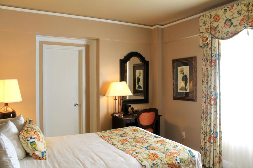 a hotel room with a bed and a mirror at Menger Hotel in San Antonio