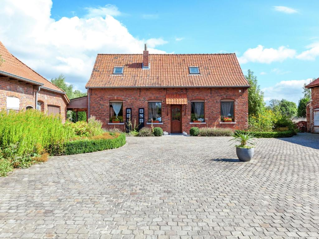 a brick house with a brick driveway in front of it at Cozy Holiday Home in Ploegsteert with a Garden in Le Bizet