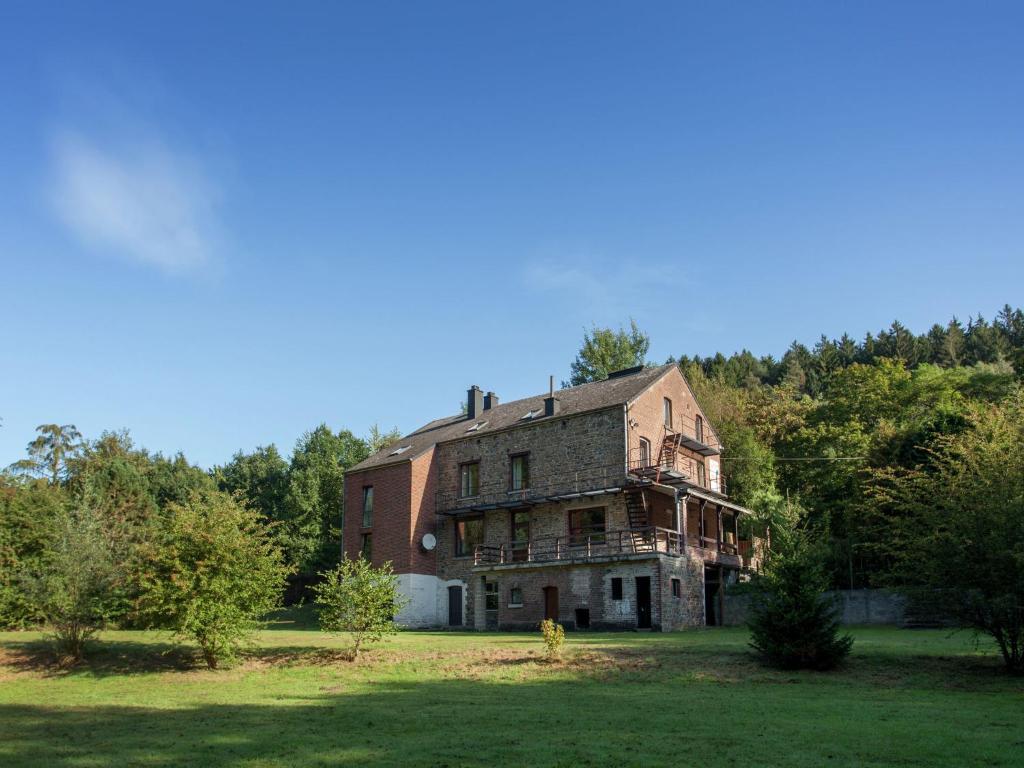 an old brick house in the middle of a field at Spacious holiday home with roofed terrace in La Gleize